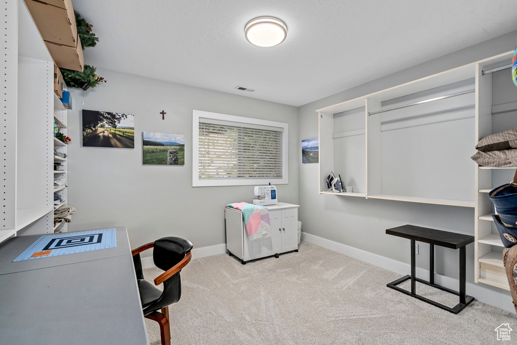 Carpeted home office featuring baseboards