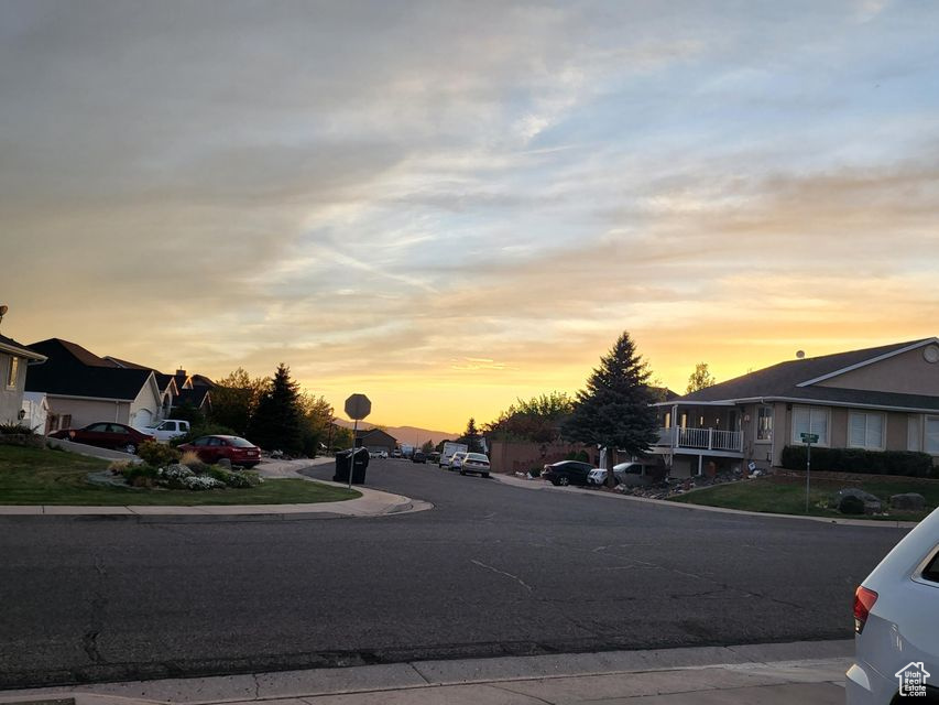 View of asphalt road featuring a residential view, sidewalks, and curbs