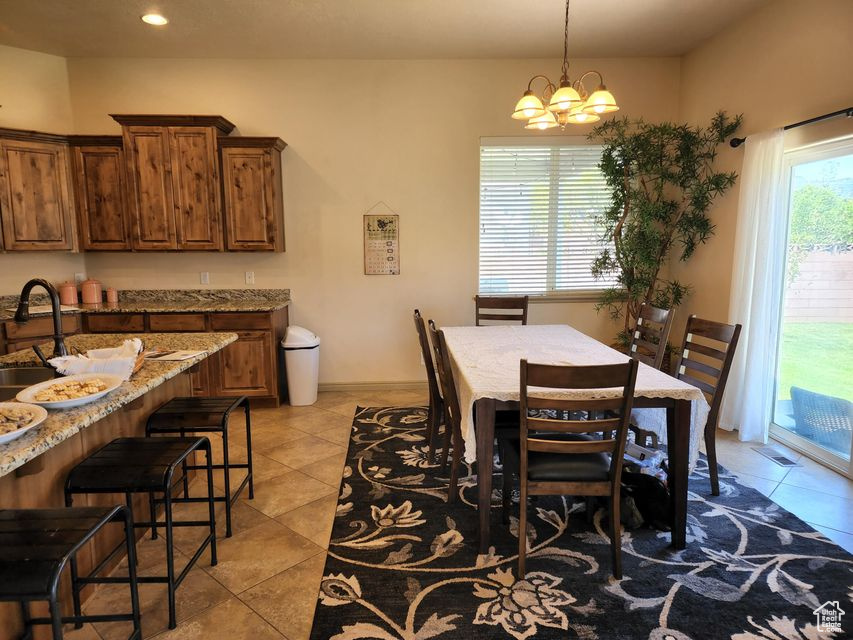 Dining room with light tile patterned flooring, a chandelier, and recessed lighting