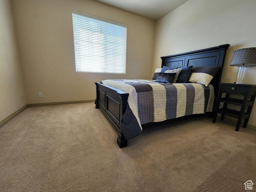 Bedroom with light carpet and baseboards
