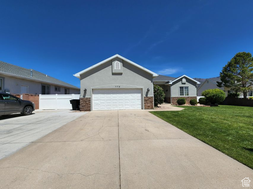 Ranch-style home featuring driveway, stucco siding, and a garage