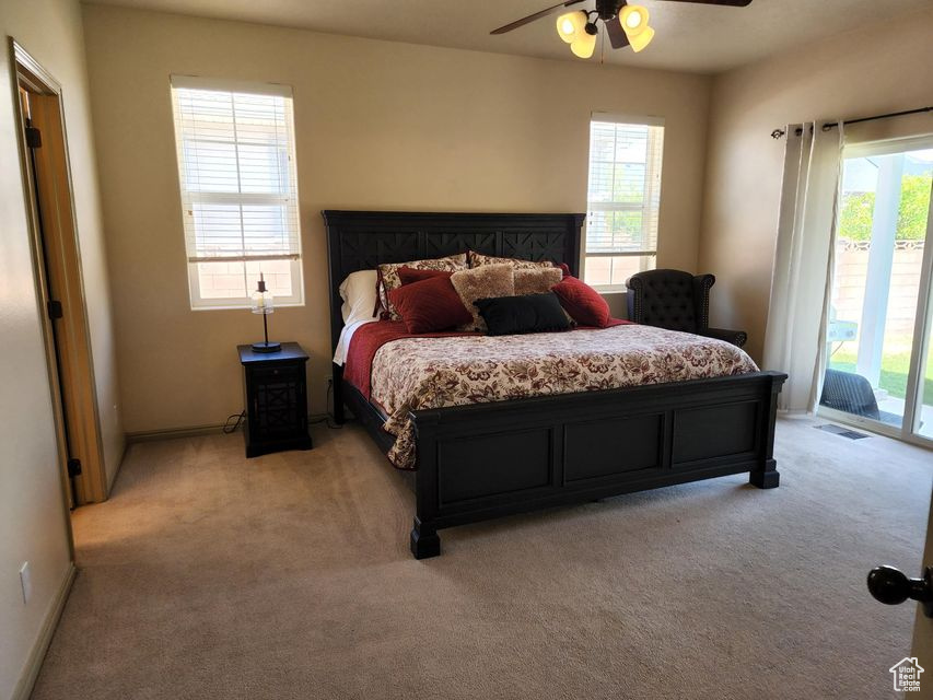 Bedroom with access to outside, light carpet, a ceiling fan, and baseboards