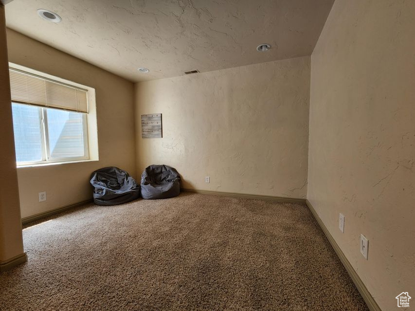 Empty room featuring carpet and baseboards