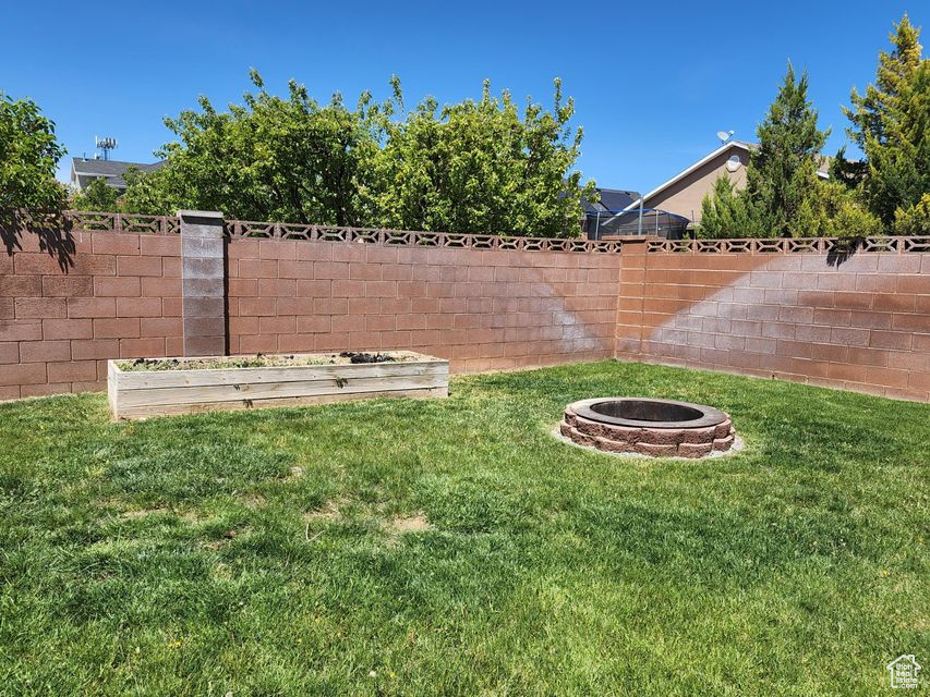 View of yard with an outdoor fire pit and a vegetable garden