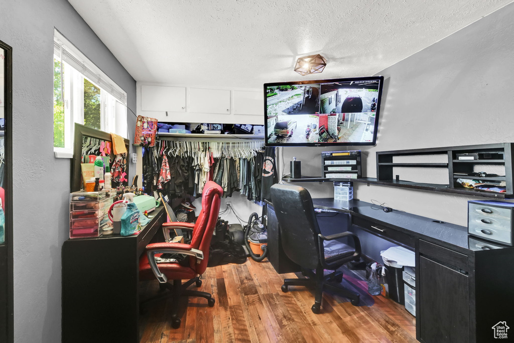 Office space with wood finished floors and a textured ceiling