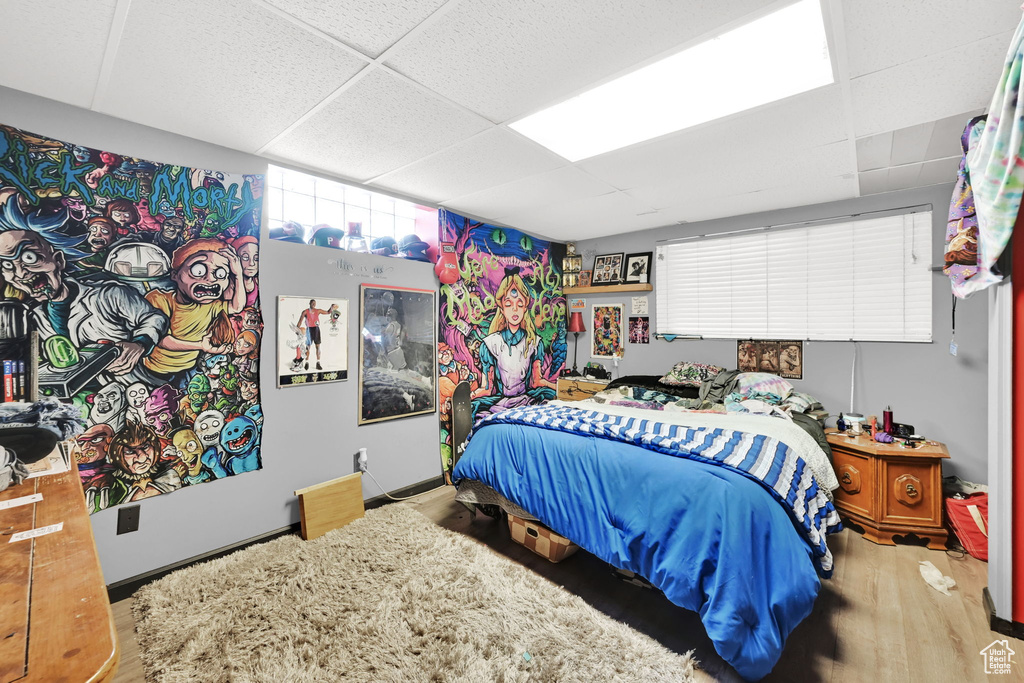 Bedroom featuring a drop ceiling and wood finished floors
