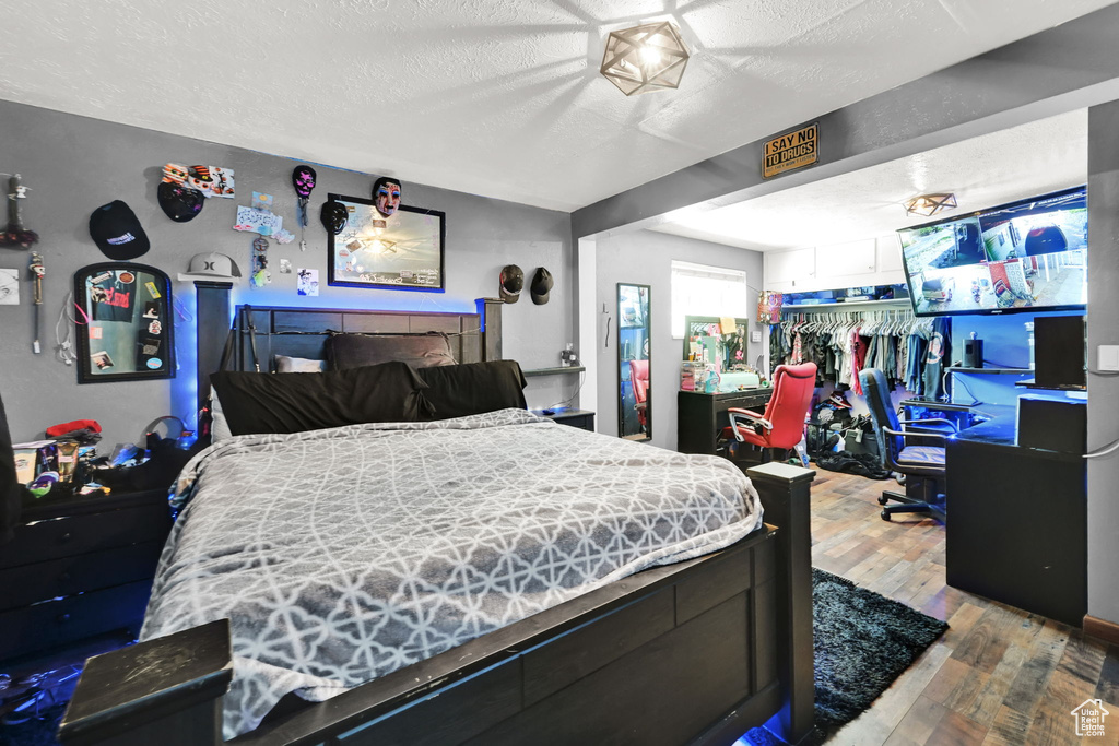 Bedroom featuring hardwood / wood-style floors and a textured ceiling