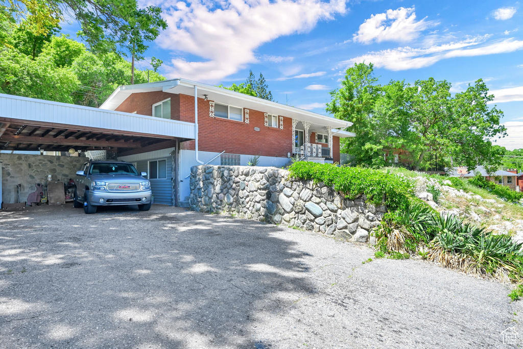 View of front of home featuring brick siding and gravel driveway