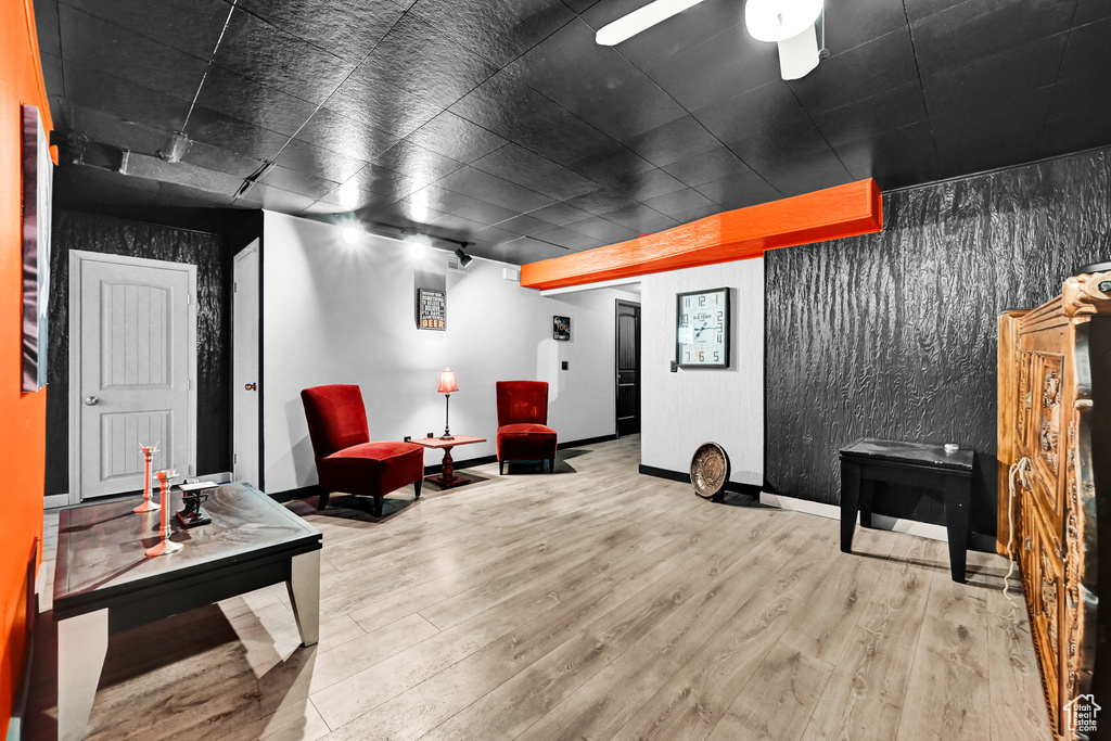 Living area featuring wood finished floors, baseboards, and ceiling fan