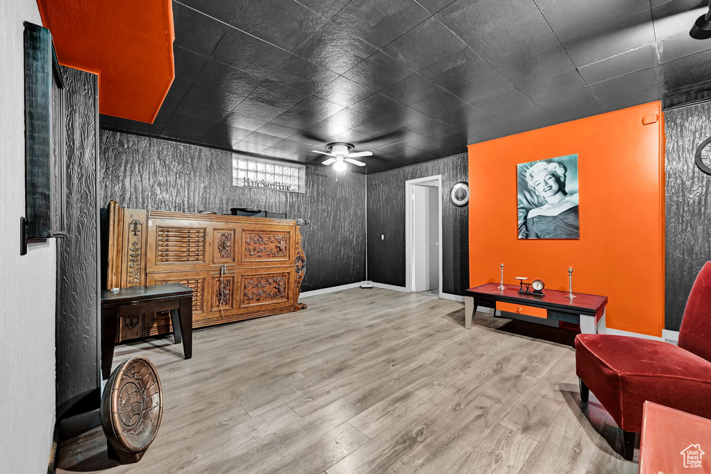 Living area with ceiling fan, wood finished floors, and baseboards