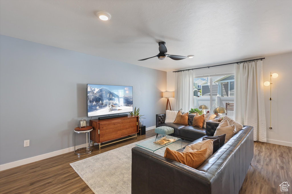 Living room with baseboards, wood finished floors, and a ceiling fan