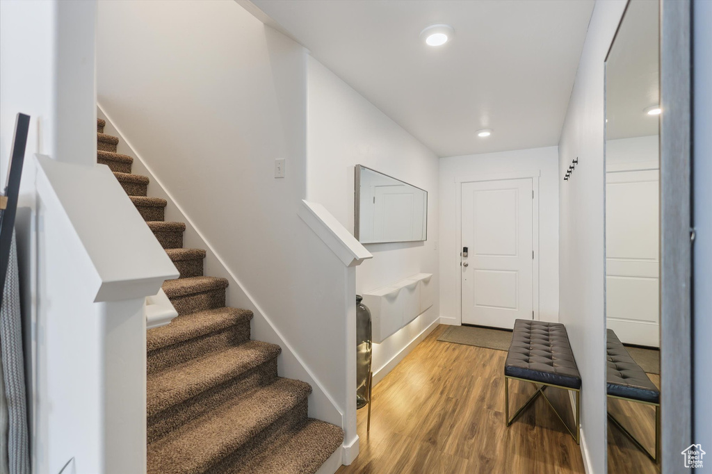 Entrance foyer with stairs, wood finished floors, recessed lighting, and baseboards