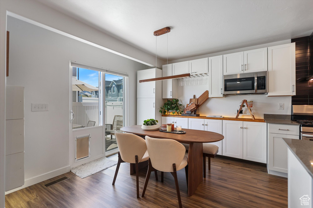 Kitchen with stainless steel appliances, dark wood finished floors, and white cabinets