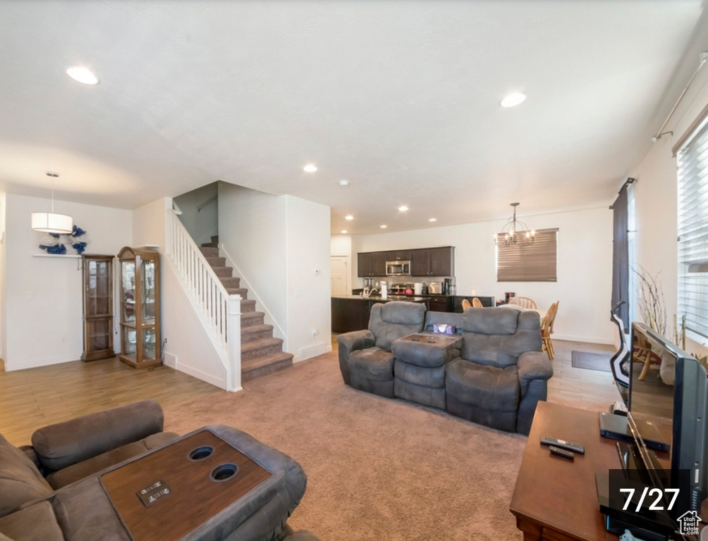 Living room featuring stairway, a chandelier, recessed lighting, and baseboards