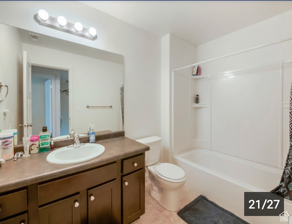 Bathroom with vanity, toilet, shower / bath combo with shower curtain, and tile patterned floors