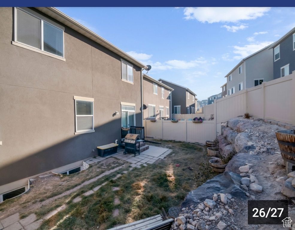 Fenced backyard featuring a patio area and a residential view