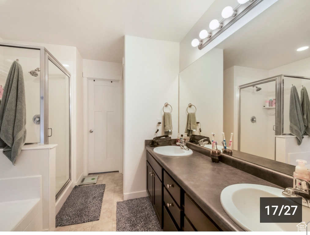 Bathroom with a stall shower, double vanity, tile patterned floors, and a bath
