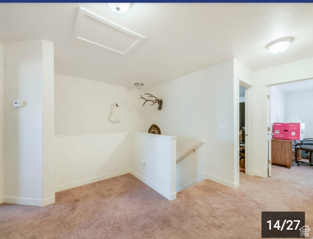 Hall featuring attic access, carpet flooring, and baseboards