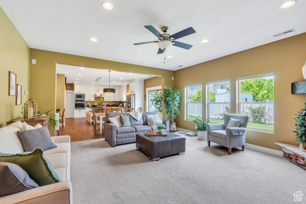 Living area featuring carpet floors, recessed lighting, a ceiling fan, and baseboards