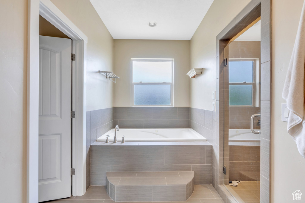 Bathroom with a bath, a stall shower, and healthy amount of natural light