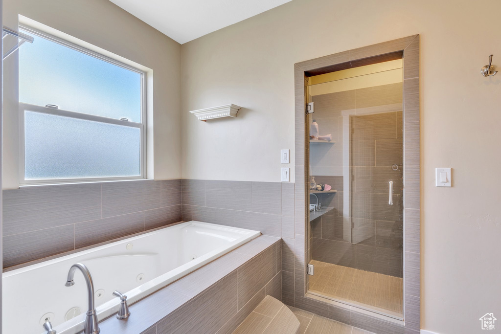 Bathroom featuring a tub with jets and a shower stall