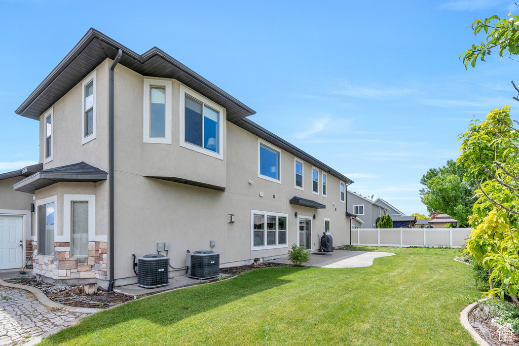 Rear view of house featuring central air condition unit, a patio area, and stucco siding