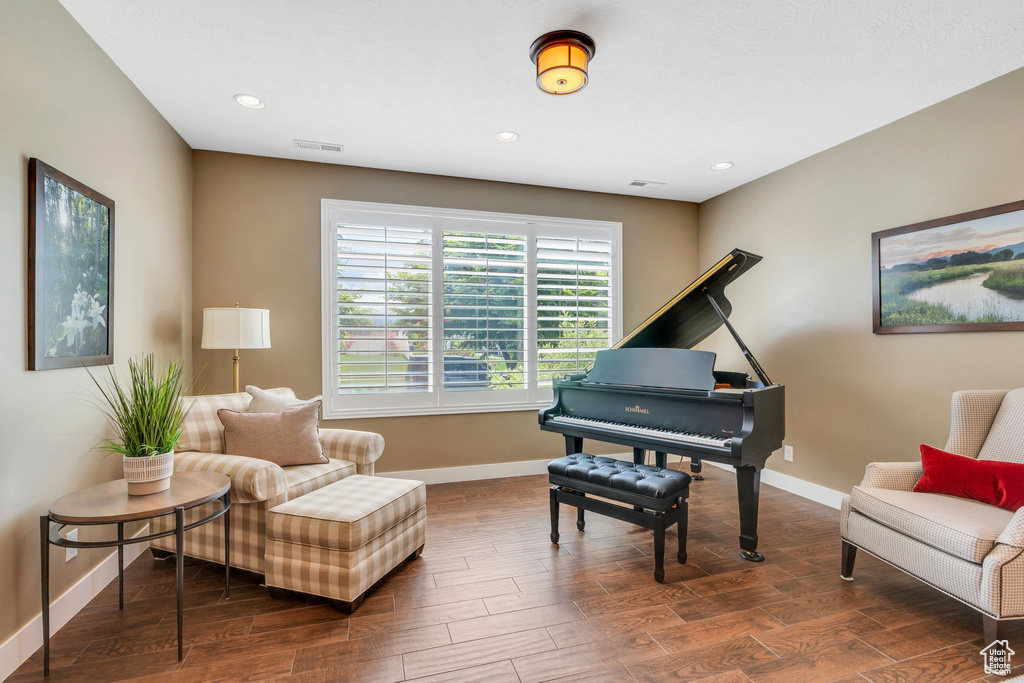 Living area featuring baseboards, dark wood-style floors, and recessed lighting