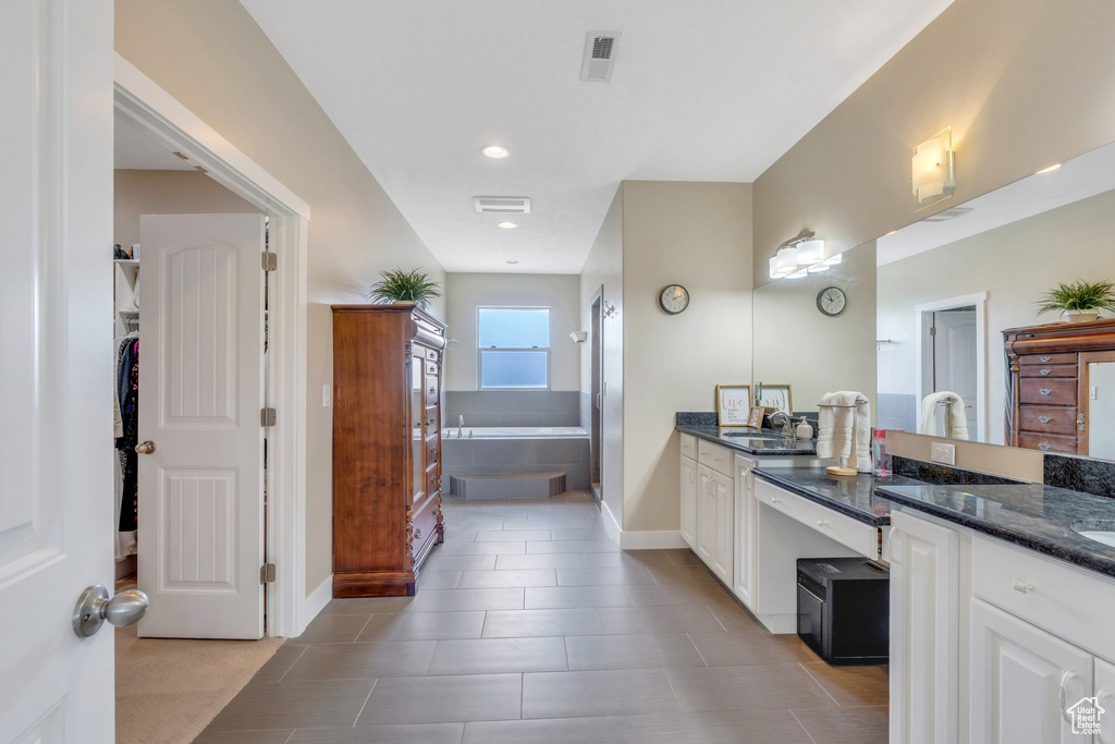 Bathroom with vanity, a bath, baseboards, tile patterned floors, and recessed lighting