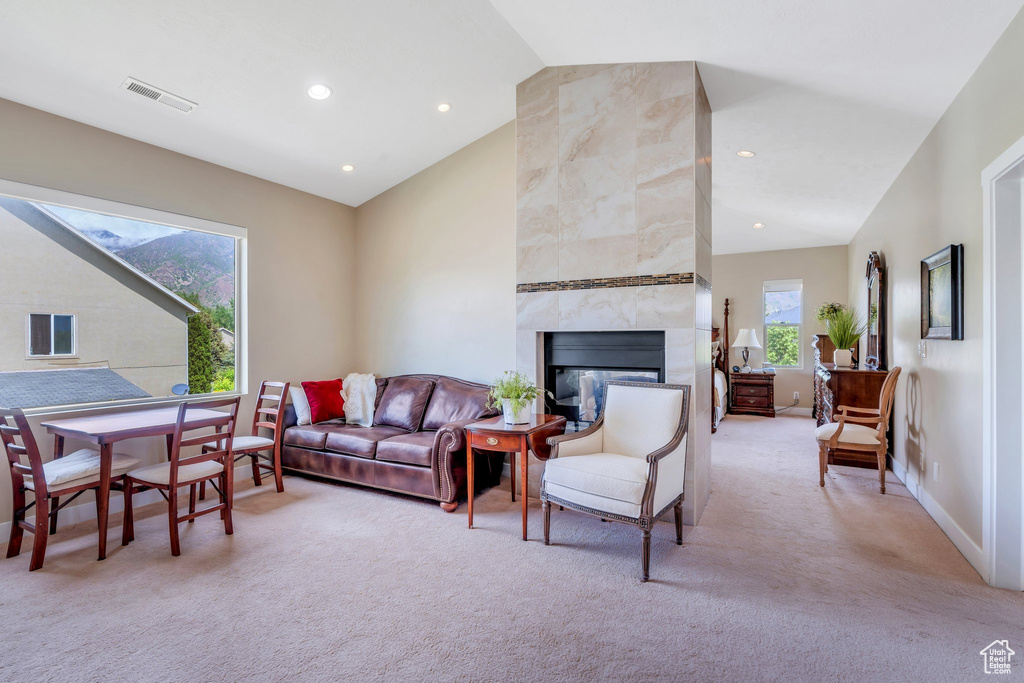 Living area with lofted ceiling, light colored carpet, recessed lighting, a tile fireplace, and baseboards
