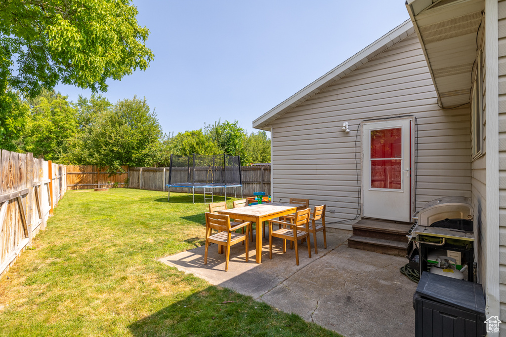 View of yard featuring a patio area, a trampoline, and entry steps