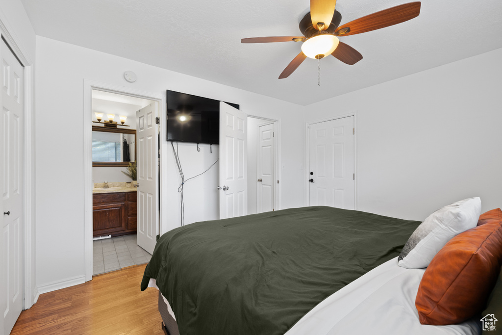 Bedroom featuring light wood-type flooring, ensuite bath, and ceiling fan