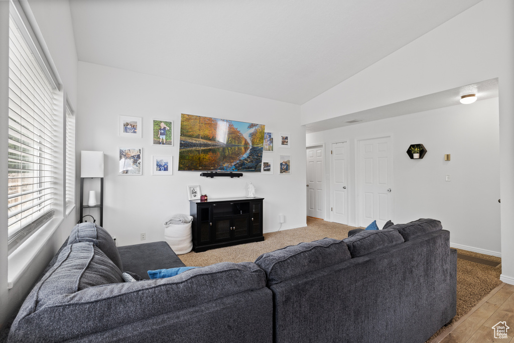 Living area featuring baseboards, wood finished floors, and high vaulted ceiling