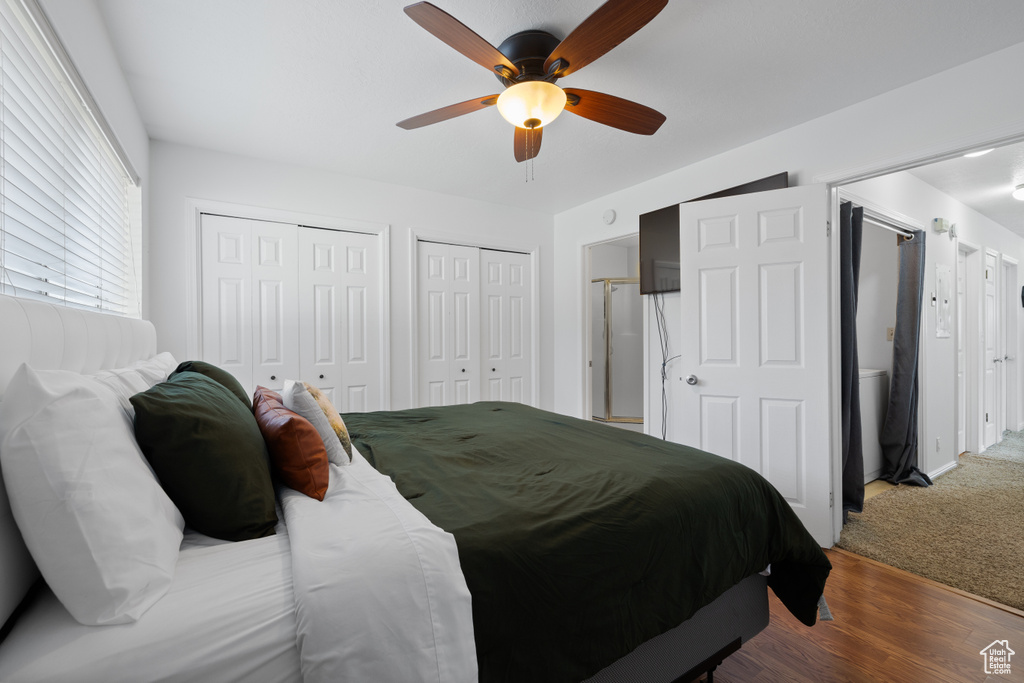 Bedroom featuring multiple closets, a ceiling fan, and wood finished floors