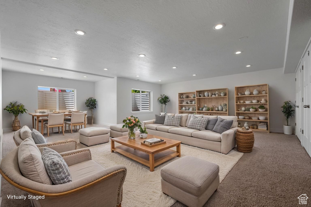 Living area with recessed lighting, a textured ceiling, and carpet flooring