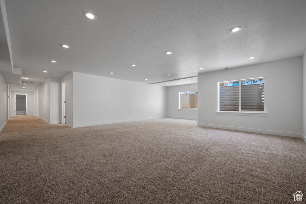 Spare room with light colored carpet, recessed lighting, baseboards, and a textured ceiling