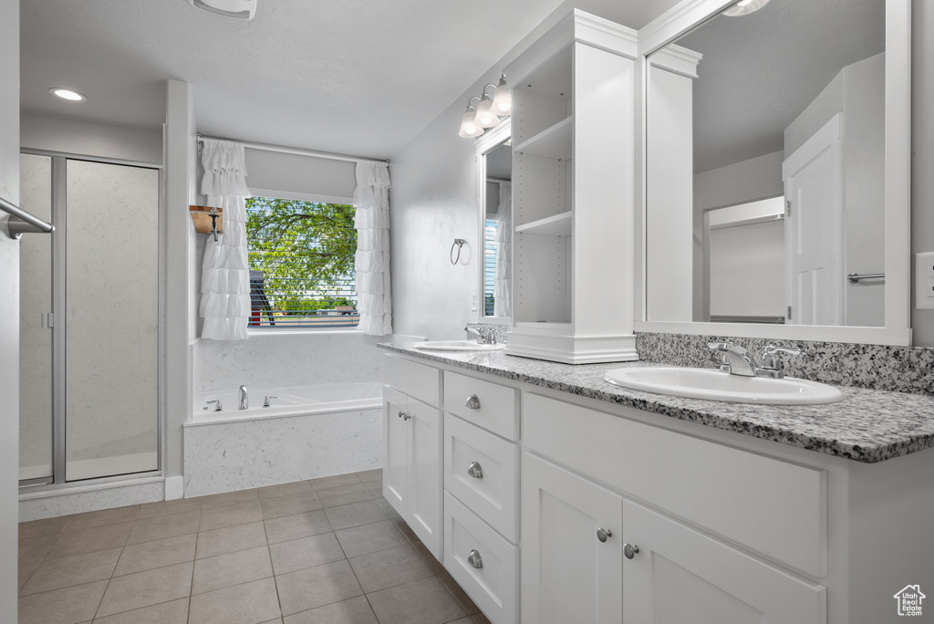 Bathroom with double vanity, a bath, a shower stall, and tile patterned floors