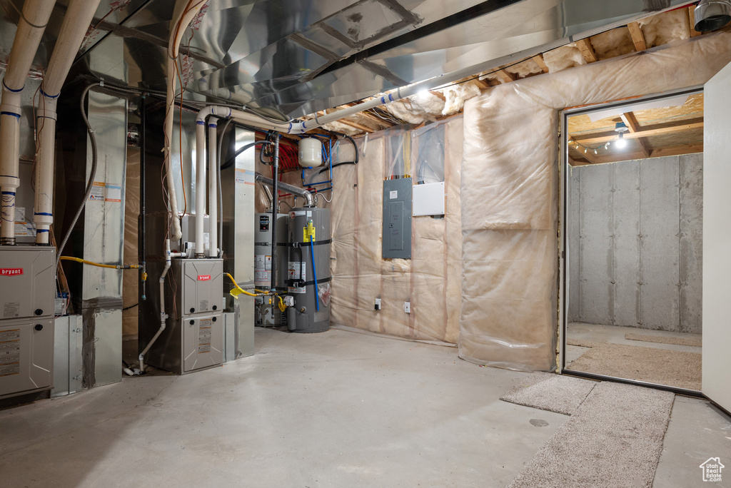 Unfinished below grade area featuring secured water heater and electric panel