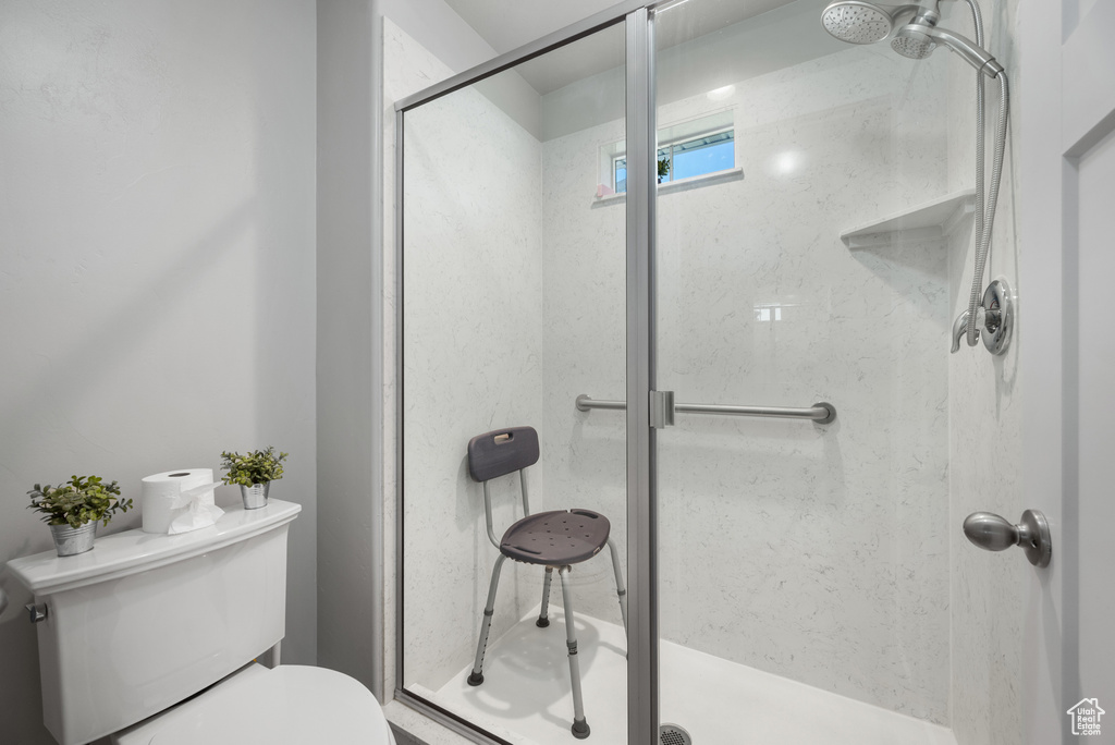 Bathroom featuring a shower stall and toilet