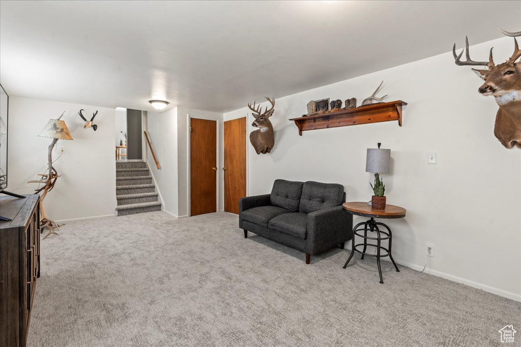 Sitting room featuring carpet, stairway, and baseboards