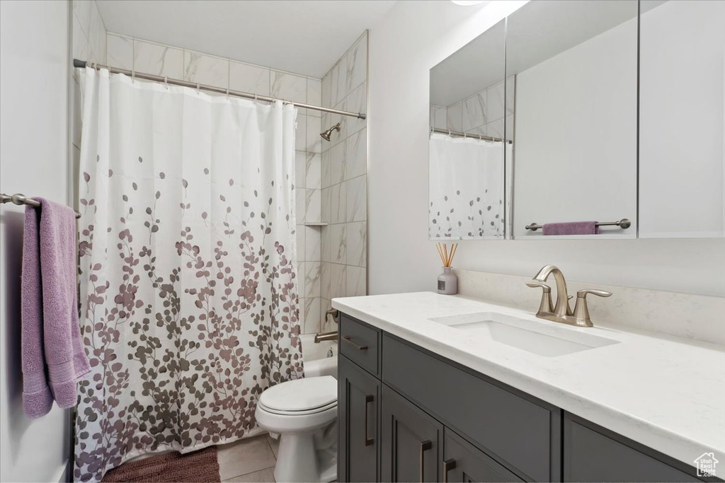 Full bathroom featuring vanity, toilet, shower / tub combo, and tile patterned floors