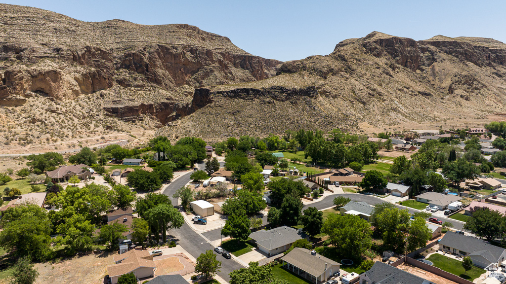 Aerial view of property and surrounding area featuring nearby suburban area and a mountainous background