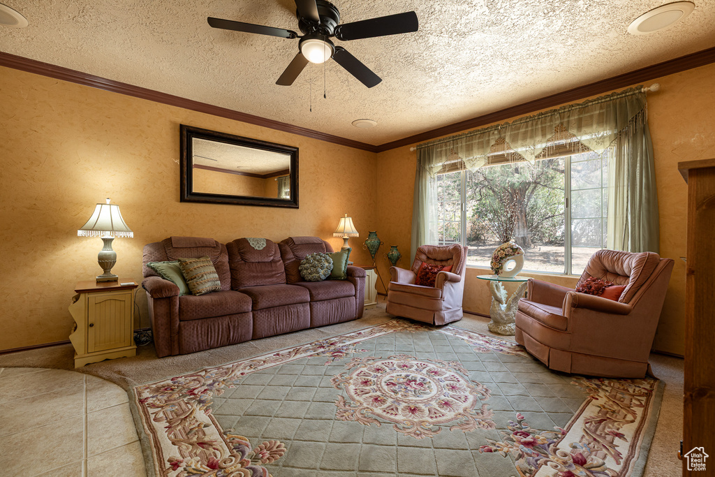 Tiled living room with a ceiling fan, a textured ceiling, and crown molding