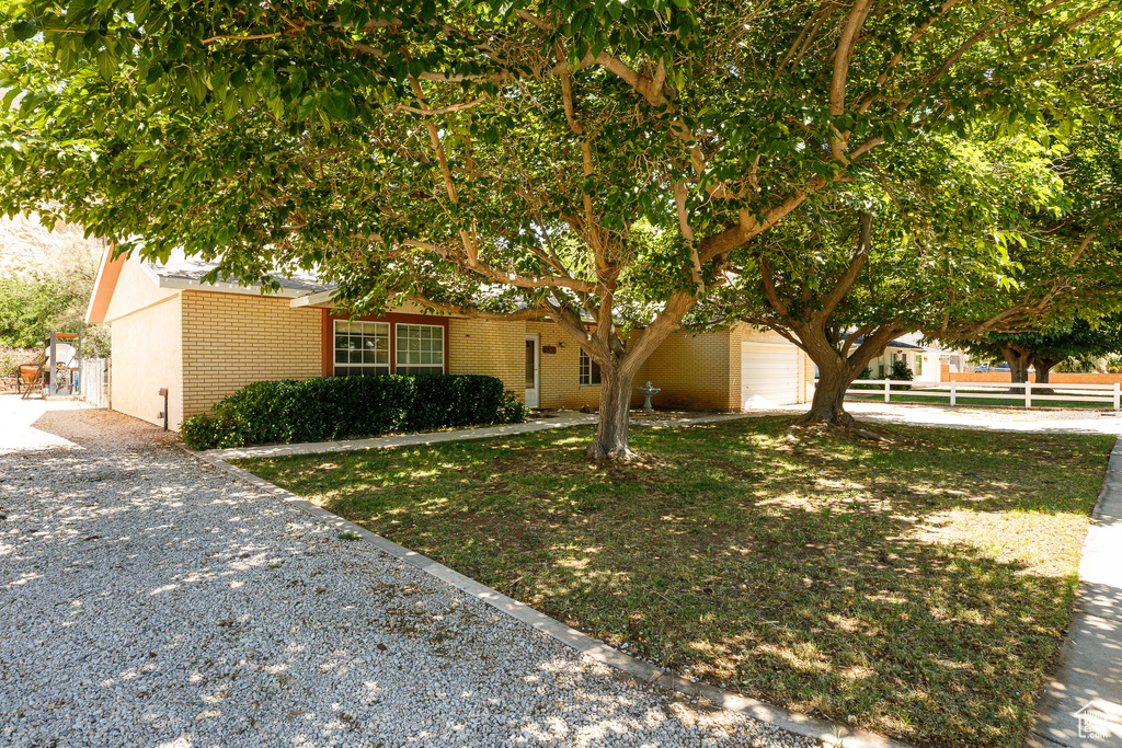 View of front of house with brick siding, a garage, and driveway