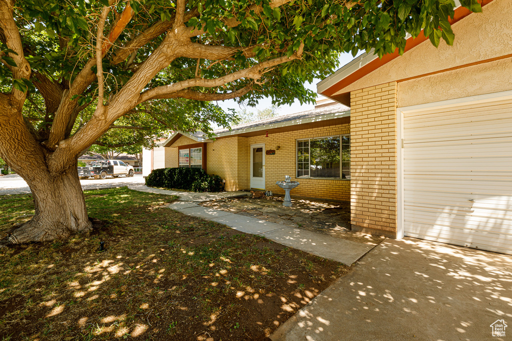 View of side of home featuring brick siding and a garage
