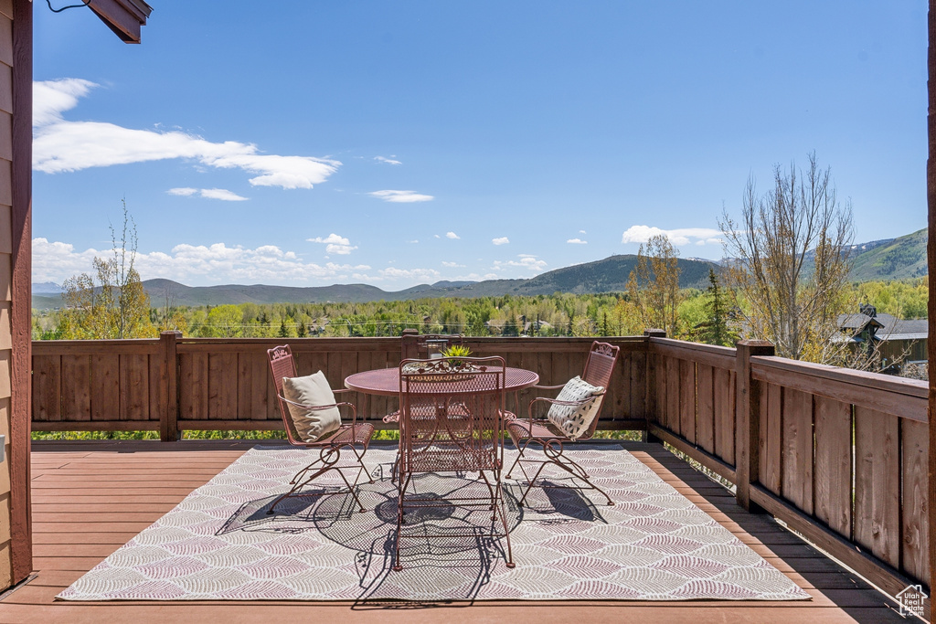 View of patio featuring outdoor dining area and a deck with mountain view