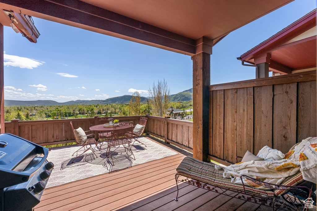 Deck featuring a mountain view, outdoor dining space, and area for grilling