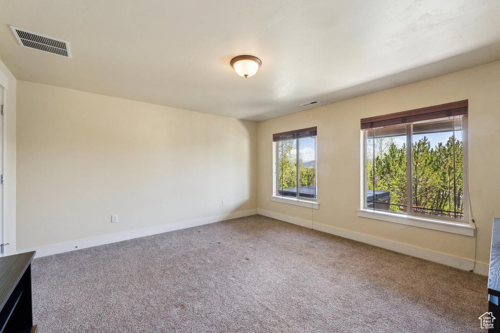 Carpeted empty room featuring baseboards