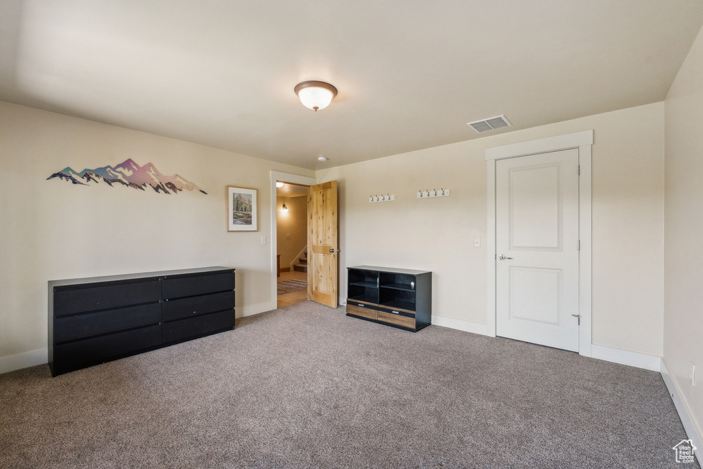 Unfurnished bedroom with carpet flooring and baseboards