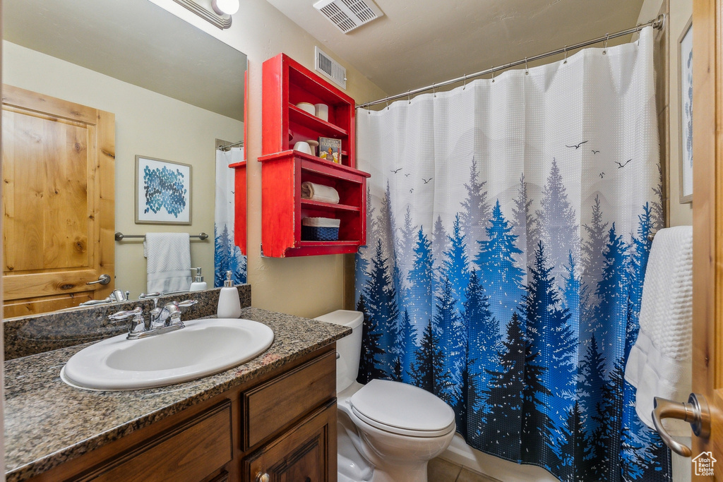 Bathroom featuring vanity, toilet, and a shower with curtain