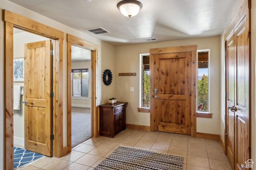 Foyer featuring baseboards and light tile patterned flooring